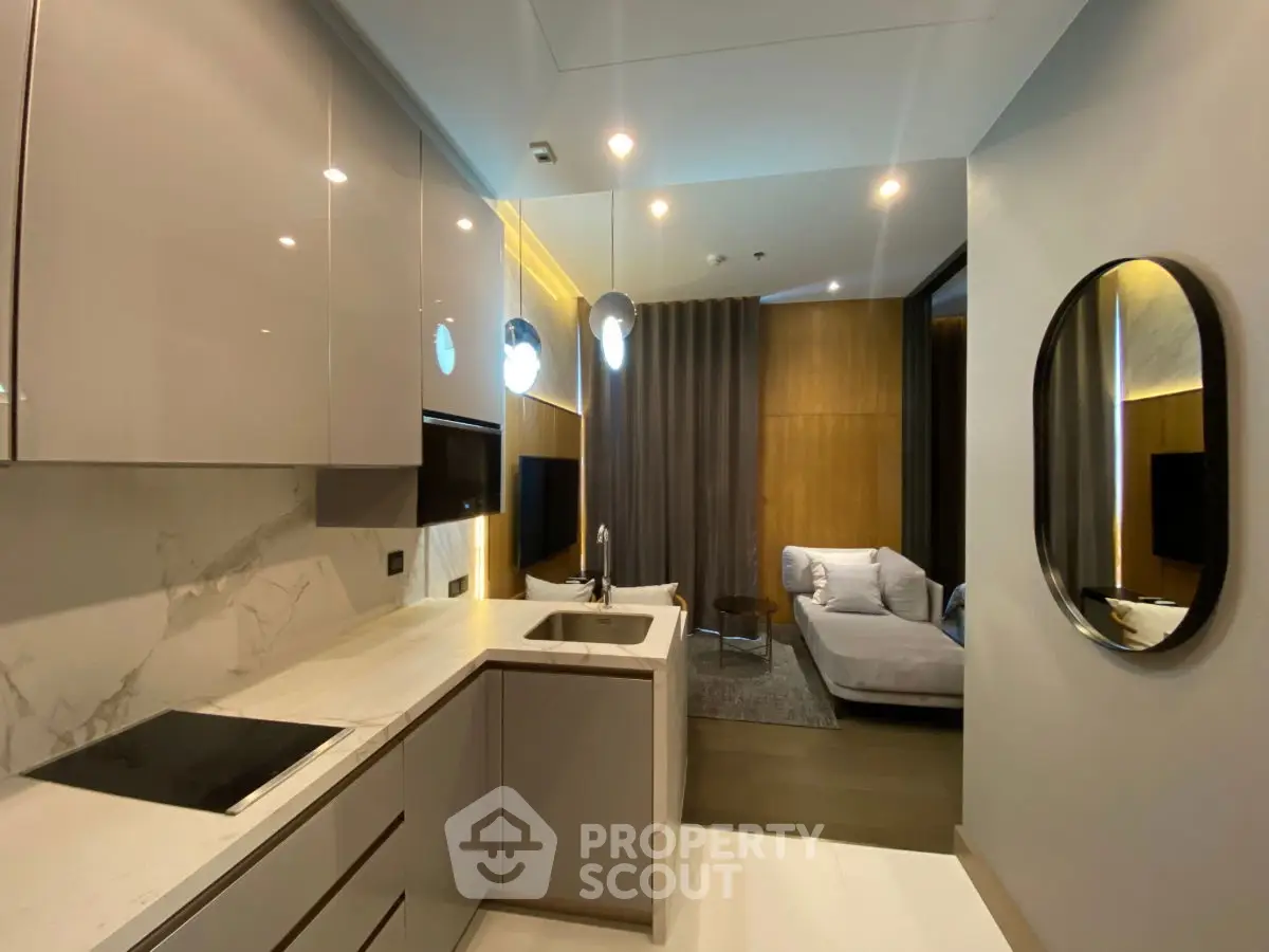 Modern open kitchen with sleek design leading to cozy living area