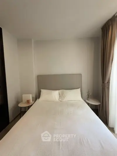 Cozy bedroom with elegant decor and natural light, featuring a comfortable bed and stylish side tables.