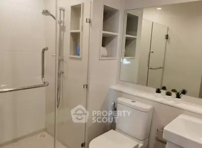 Modern bathroom with glass shower, sleek fixtures, and minimalist decor.