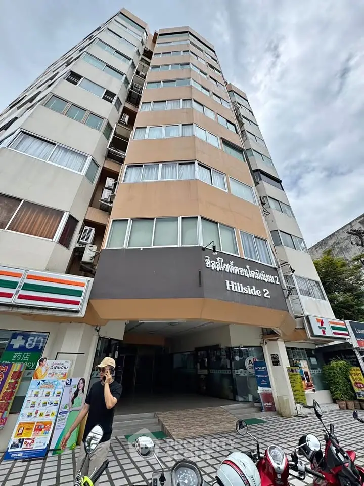 High-rise residential building with street-level shops and parking area