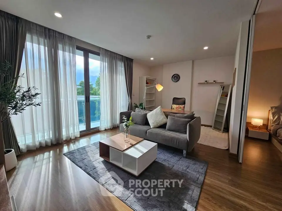 Modern living room with stylish decor and large windows offering natural light and a view.