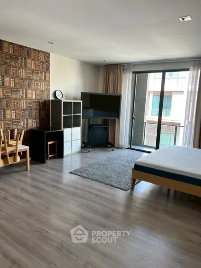 Spacious modern living room with large TV and balcony access