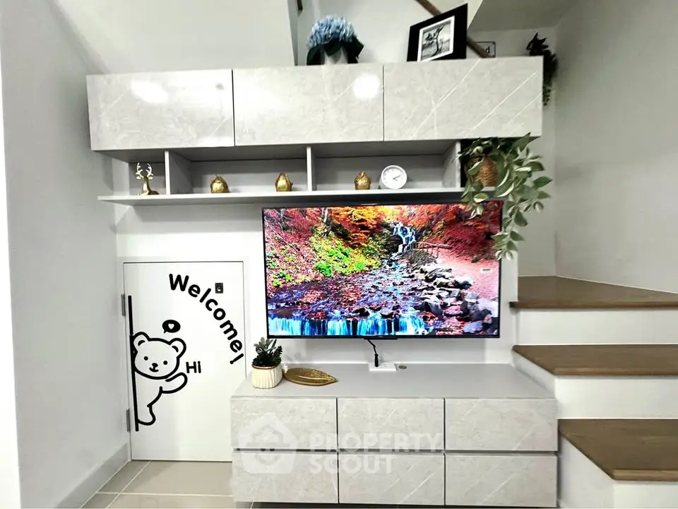 Modern living room with sleek storage and TV, featuring stylish decor and welcoming ambiance.