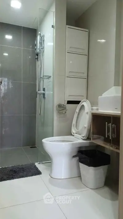 Modern bathroom with sleek design, featuring a glass shower and contemporary fixtures.