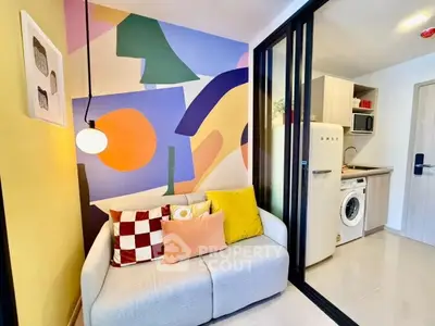 Modern living room with colorful wall art and compact kitchen area