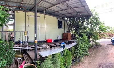 Charming rustic exterior with covered porch and lush greenery, perfect for serene living.