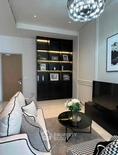 Elegant living room with modern decor, featuring a stylish black shelving unit and chic lighting.