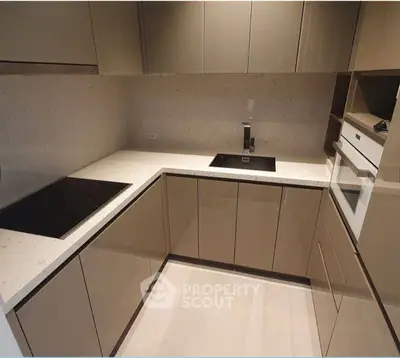 Modern kitchen with sleek cabinetry and built-in appliances in a contemporary apartment.