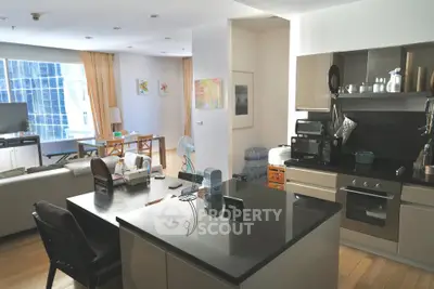 Modern open-plan kitchen and living room with sleek appliances and city view.