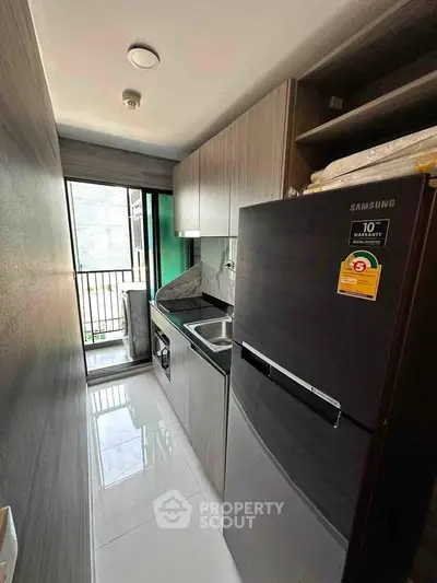 Modern compact kitchen with sleek appliances and balcony view