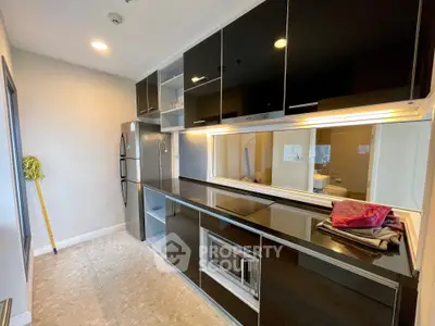 Modern kitchen with sleek black cabinets and built-in appliances in a stylish apartment.