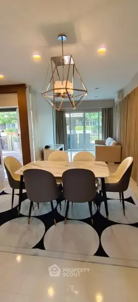 Modern dining area with stylish chandelier and large windows