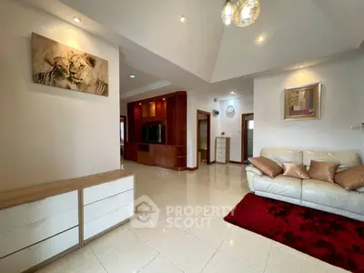 Spacious living room with modern decor and elegant lighting, featuring a cozy white sofa and stylish artwork.