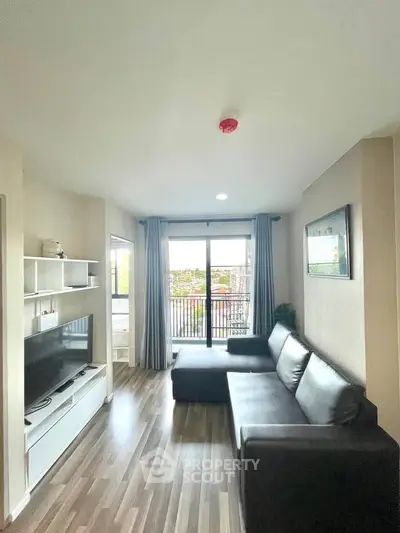 Modern living room with sleek furniture and balcony view, perfect for urban living.
