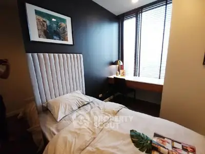 Cozy bedroom with modern decor and large window for natural light.