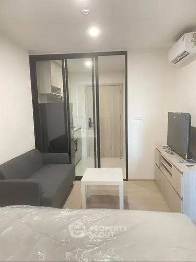 Modern studio apartment with sleek interior design and compact layout, featuring a cozy living area and kitchenette.