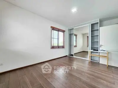 Spacious bedroom with wooden flooring and mirrored closet doors