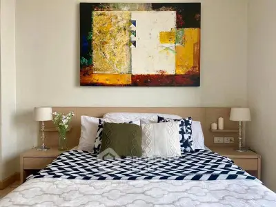 Stylish bedroom with modern art and cozy bedding in a contemporary home.