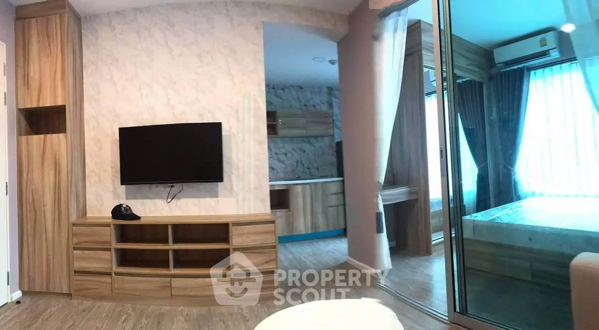Modern apartment interior with wooden furniture and glass partition, featuring a cozy bedroom and living area.