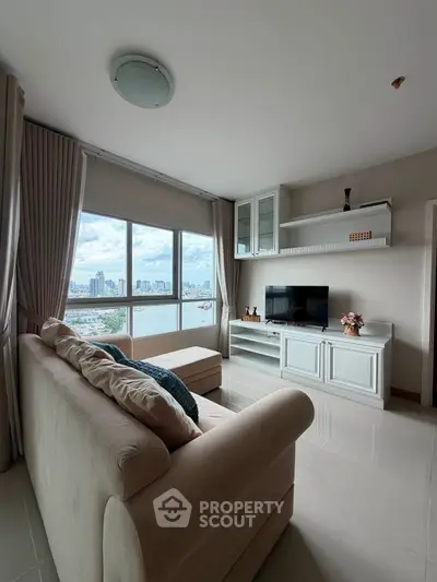 Spacious living room with stunning city view, modern furnishings, and ample natural light.