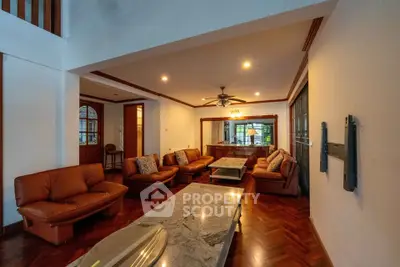 Spacious living room with elegant wooden flooring and cozy leather sofas