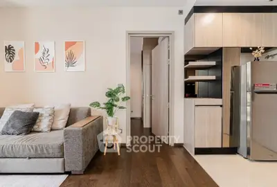 Modern living room with stylish decor and sleek kitchen area, featuring a cozy sofa and contemporary artwork.
