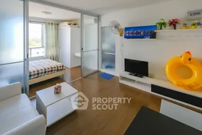 Modern living room with open layout and bedroom view, featuring stylish decor and natural light.