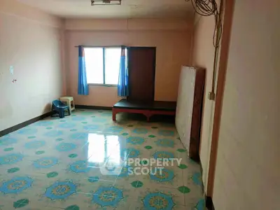 Spacious room with tiled flooring and natural light, ideal for versatile living arrangements.