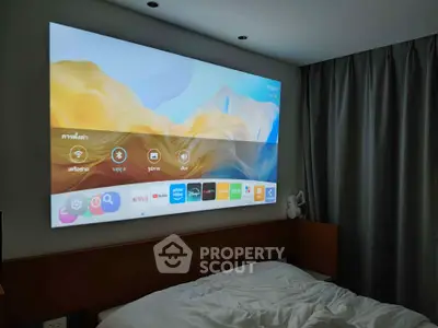 Modern bedroom with a wall-mounted projector displaying streaming apps, creating a cozy entertainment space.