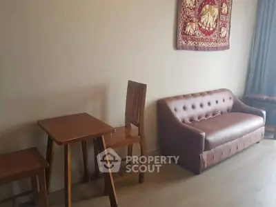 Cozy living room with brown leather sofa and wooden dining set, perfect for modern living.