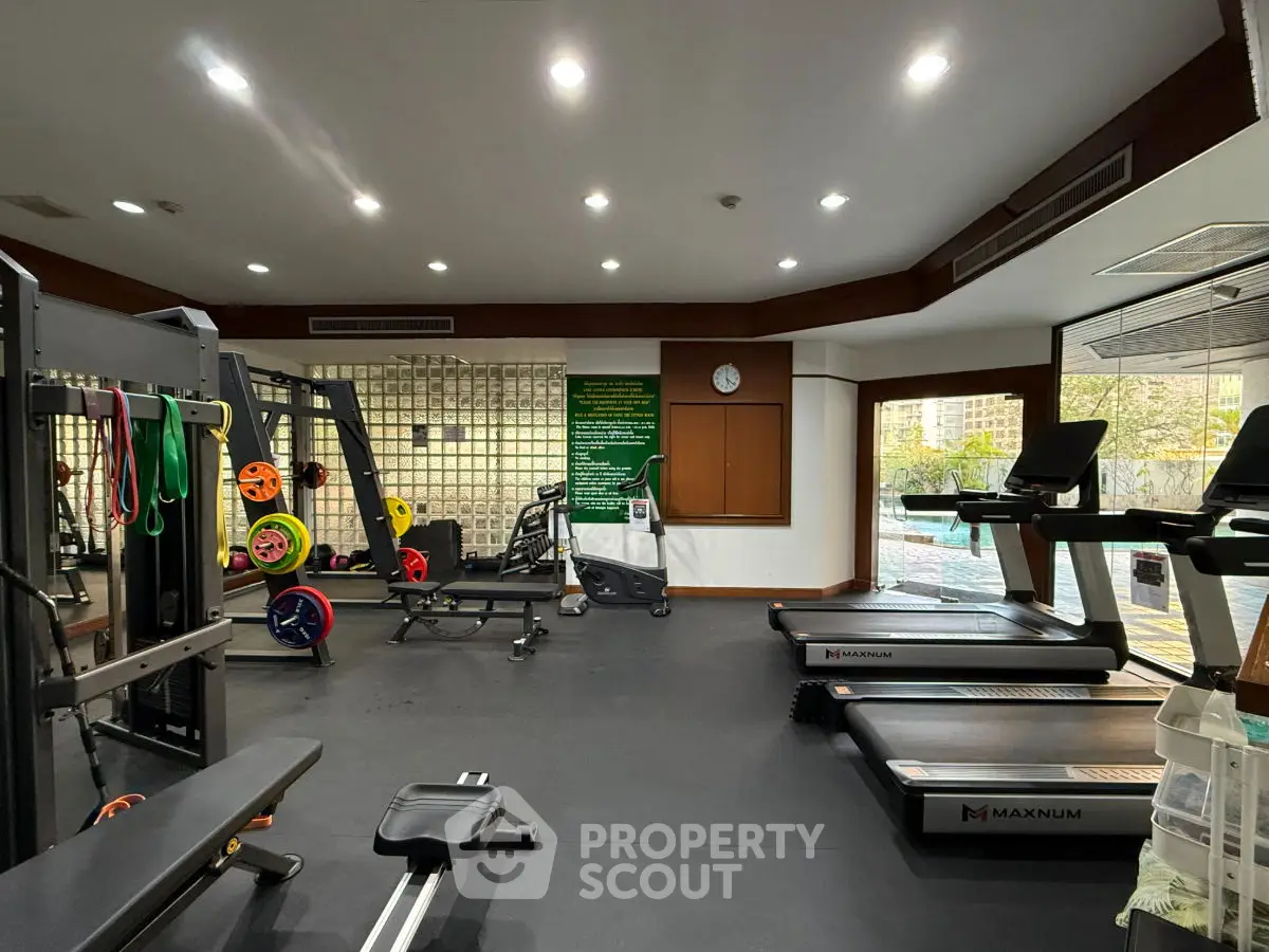 Modern gym with state-of-the-art equipment and large windows for natural light.