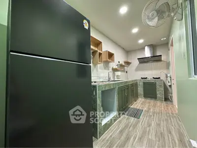 Modern kitchen with sleek appliances and open layout, featuring a gas stove and ample storage space.
