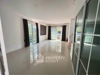 Spacious modern living room with large windows and glossy tiled floors
