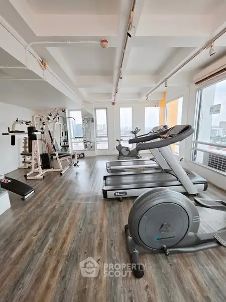 Modern gym with state-of-the-art equipment and city view, perfect for fitness enthusiasts.