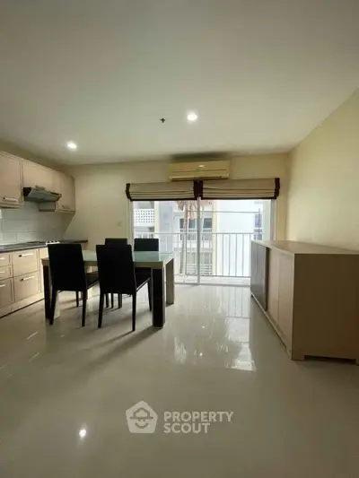 Spacious kitchen with dining area and large window in modern apartment