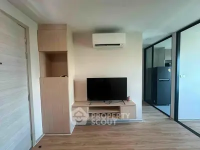 Modern living room with sleek TV setup and air conditioning in stylish apartment.