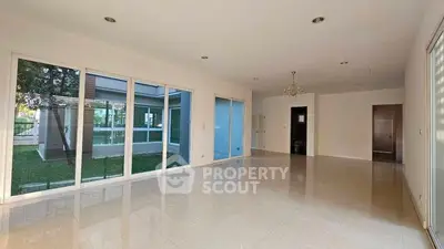 Spacious empty living room with large windows and garden view