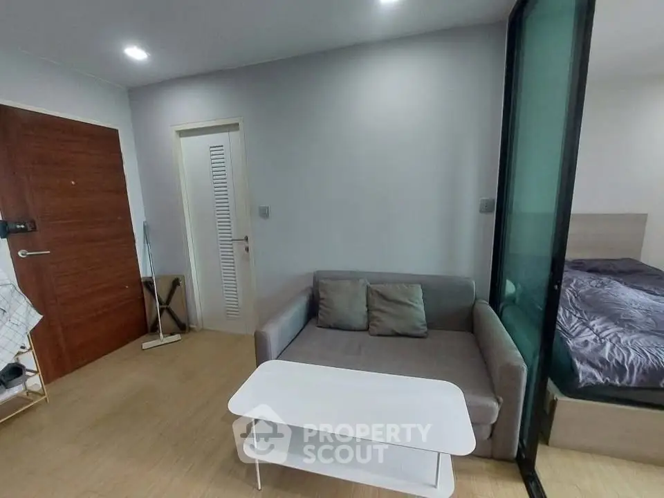 Modern living room with cozy sofa and sliding door to bedroom