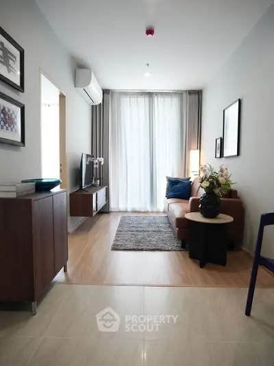 Modern living room with stylish decor, cozy seating, and natural light through large windows.