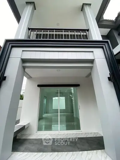 Modern two-story building exterior with sleek design and large glass doors.