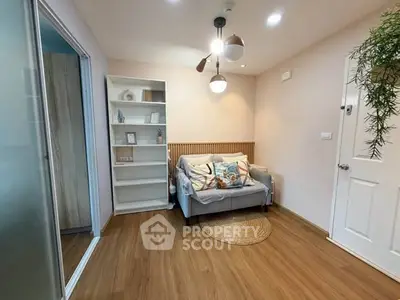 Cozy living room with modern decor and wooden flooring, featuring a comfortable sofa and stylish lighting.