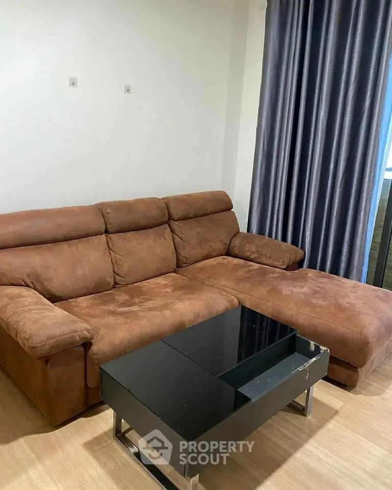 Cozy living room with brown sectional sofa and modern black coffee table.