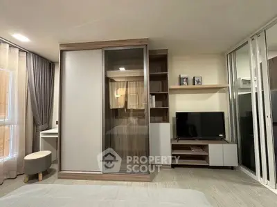 Modern bedroom with sleek wardrobe and entertainment unit, perfect for stylish living.