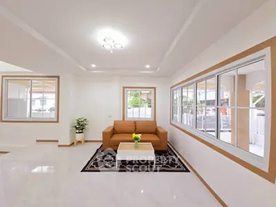 Spacious living room with modern sofa and large windows, perfect for natural light.