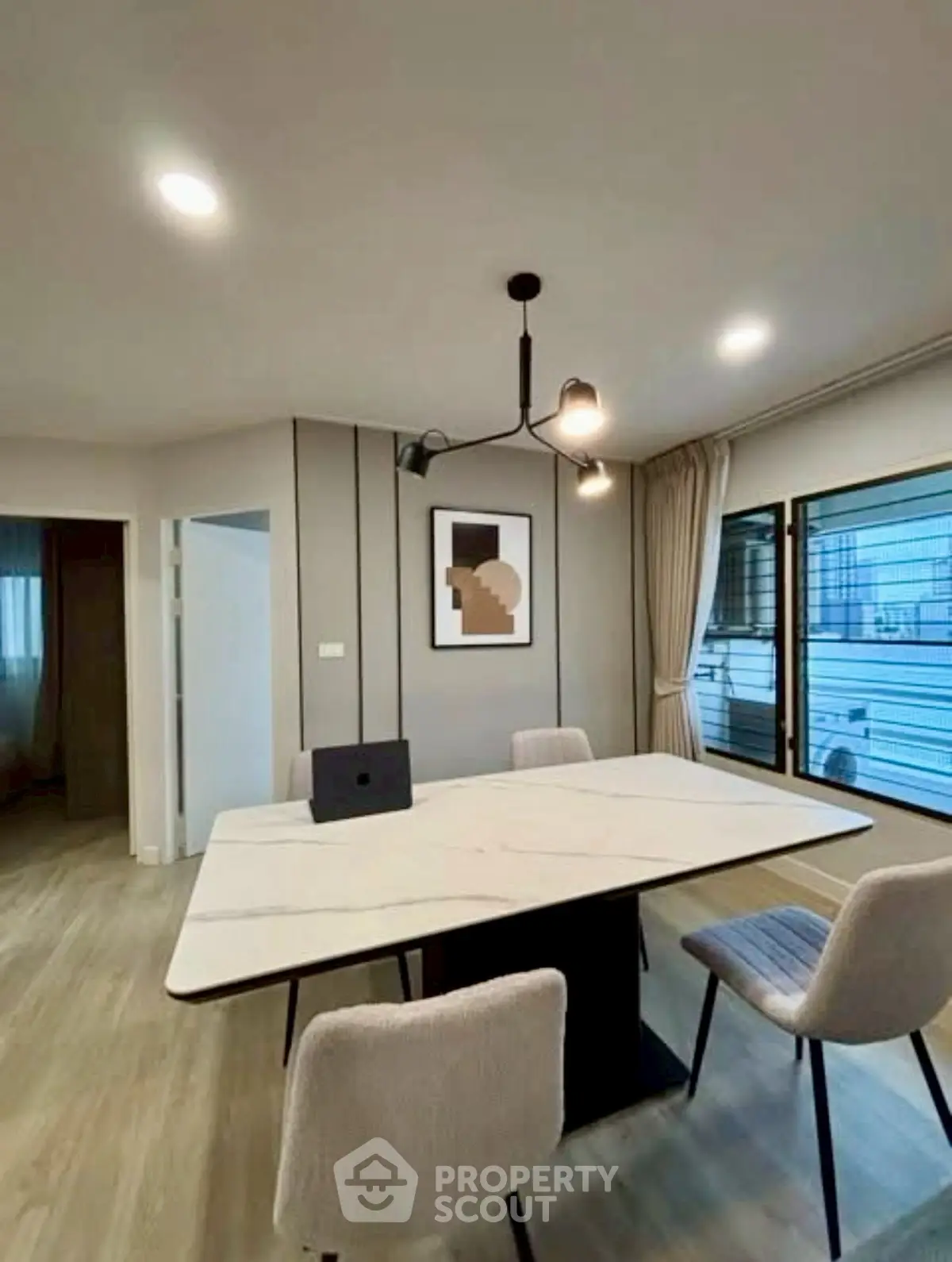 Modern dining area with elegant table and chairs, featuring stylish lighting and wall art.