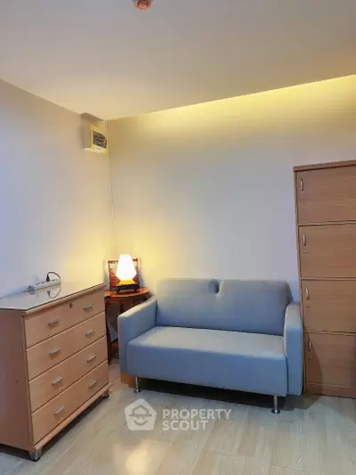 Cozy living room with modern sofa and wooden furniture, perfect for relaxation.