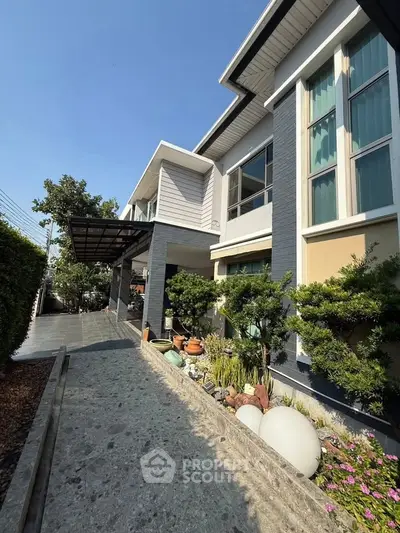Modern two-story house with landscaped garden and large windows