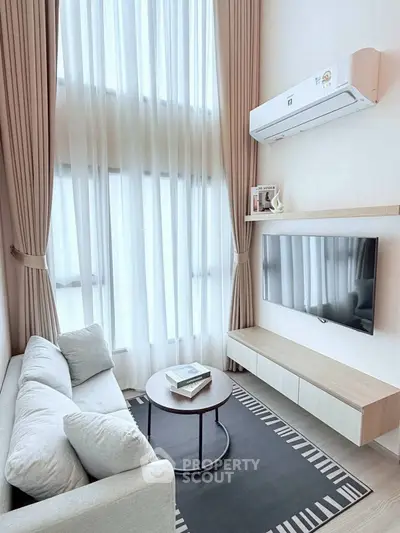 Modern living room with high ceilings, large windows, and sleek furniture design.