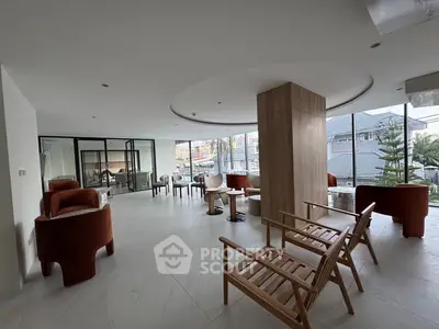 Spacious modern living room with elegant seating and large windows offering city views.
