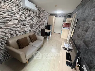 Modern living room with stylish stone accent wall and compact kitchen area